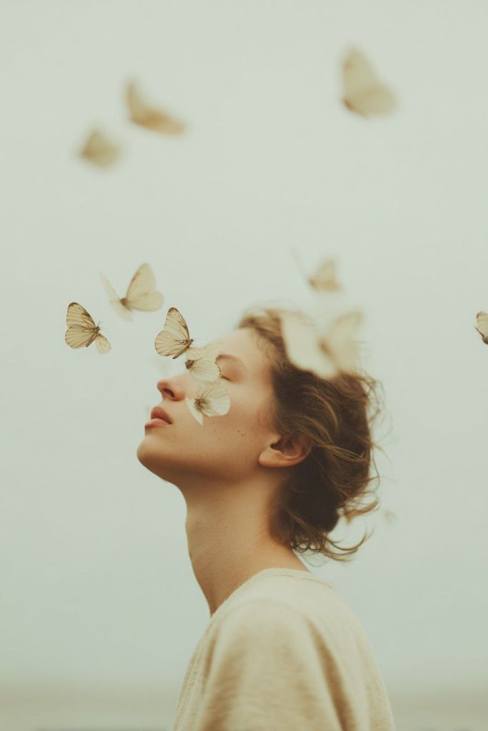 Femme les yeux fermés, papillons autour d'elle — éveil intérieur